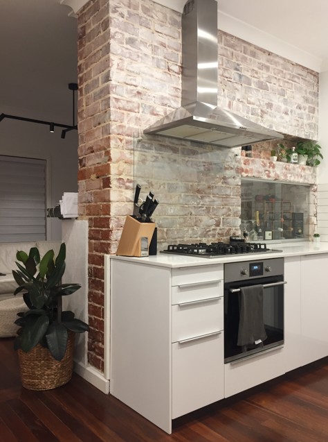 Kitchen renovation with exposed brickwork and modern stainless steel appliances
