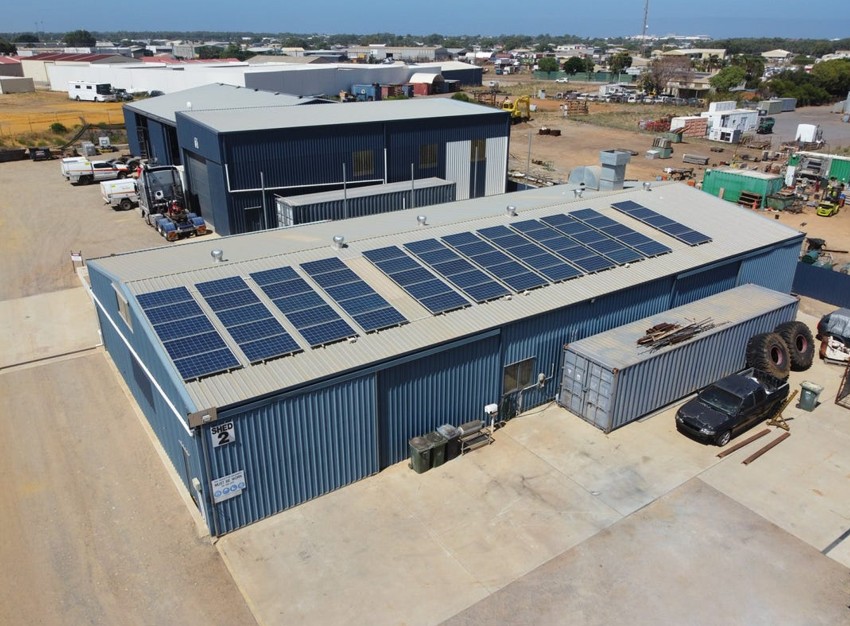 Aerial view of an industrial warehouse with rooftop solar panels